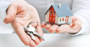 Person holding moDel house and keys
