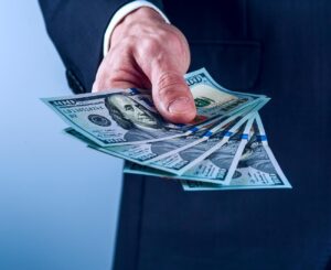 Businessman Man Handing $100 bills out - New-build buyer rebate credit at closing